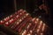 People lighting candles in the Notre Dame cathedral in Paris, France. Burning a candle is a usual practice in Catholicism