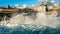 People look at the big waves crashing on the pier. Tourists contemplate the splashes of waves crashing on the rocky shore during