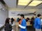 People look at products and talk to sales reps inside Apple Store with Ipad 2 ad on wall