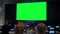 People looking at blank large interactive wall display - green screen concept