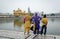 People looking at the Golden temple with the lake in Amritsar, India