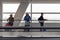 People with luggage at the airport on a moving passenger tape.