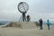 People make travel photo with symbolic globe at North Cape, Norway.