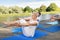 People making yoga in half-boat pose outdoors