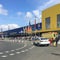 People in medical masks stand in line to enter near the IKEA store. Sunny day after lifting the quarantine and an ambulance on