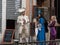 People in medieval carnival costumes- a man talks with two women in front of the closed cafe with outdoor menu in Venice
