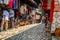 People in a medina street market with souvenirs, craft items and small shops .