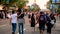 People, men, women and children walking along the road