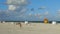 People on Miami beach on beautiful sunny day. Sand beach, tourists and yellow lifeguard tower on blue Atlantic ocean.