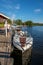 People on a moored motorboat at a boat refueling station with sailboats.