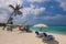 People near the White Sandy Beach with the Palm Trees and Hotel Building on the Maldivian Paradise Island