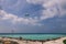 People near the White Sandy Beach with the Palm Trees and Hotel Building on the Maldivian Paradise Island