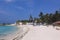 People near the White Sandy Beach with the Palm Trees and Hotel Building on the Maldivian Paradise Island