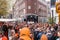 People in orange clothing are sailing in a boat on the canals of Amsterdam on King\\\'s Day