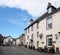 People outside the priory hotel and walking in the street near the village square and shop in cartmel cumbria