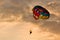 People parasailing at sunset in beautiful light.