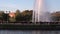 People in park on bench near fountains in summer in Moscow.