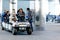 People and passengers riding in motorized carts in the airport