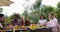 People Passing Food Eating On Terrace Young Friends Talking Sitting At Table Outdoors Communication