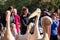 People photograph colourful pink pelicans with long beaks, by the lake in St James\'s Park, London UK.