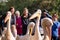 People photograph colourful pink pelicans with long beaks, by the lake in St James\'s Park, London UK.