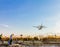 People photographing a turboprop airplane landing at Larnaca Int