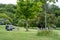 People are on a picnic and walk in the memorial park at Marselisborg Castle, green grass, green trees