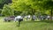 People are on a picnic and walk in the memorial park at Marselisborg Castle, green grass, green trees