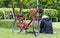 People are on a picnic and walk in the memorial park at Marselisborg Castle, woman with red bicycle, reading book