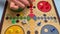 People play Ludo or Pachisi board game on beautiful wooden play board. Ludo is a strategy board game for two to four