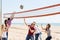 People play volleyball on beach