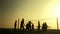 People play volleyball on the beach at sunset.