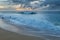 People playing on the beach with big waves on the north shore of Oahu