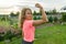 People, power, stamina, strength, health, sport, fitness concept. Outdoor portrait smiling teenage girl flexing her muscles, backg