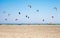 People practicing Kitesurfing. Beach on the peninsula Prasonisi, Rhodes. Colorful kites on the sea shore. Blue sea and