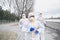 People with protective suits and respirators running outdoors, coronavirus concept.