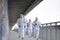 People with protective suits and respirators running outdoors, coronavirus concept.