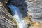 People rappelling in an impressive waterfall