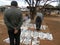 People reading newspapers at roadside stand.