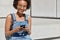 People, recreation and technology concept. Relaxed carefree black woman holds cell phone in hands, types text message