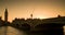 People and red buses crossing Westminster Bridge at sunset by Big Ben and the Houses of Parliament, London, England