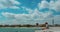 People relax on Barcelona beach. Time lapse of white clouds on sky over blue sea