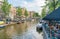 People relax late in day sitting alongside canal and in canalside cafes
