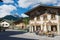 People relax at the small street cafe with traditional Bavarian painted houses at the background in Mittenwald, Germany.