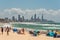 People relaxing on Burleigh beach with view of Gold Coast skyscrapers