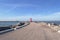 People relaxing on the pier with lighthouse on sunny day