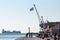 People relaxing on the quay - pier of the old port of Thessaloniki, a Greek flag and a cargo ship can be seen in the background