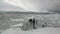 People on research expedition ship float in ice icebergs of Antarctica Ocean.