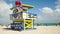 People resting on the beach arounf LifeGuard tower