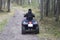 People ride an ATV in the autumn forest.Motor vehicles